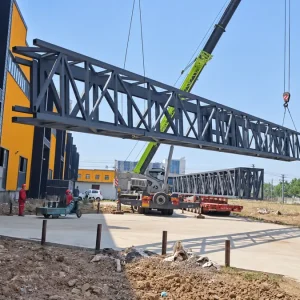 Complete steel truss column during lifting at the factory