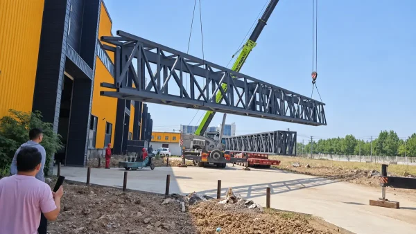 Complete steel truss column during lifting at the factory